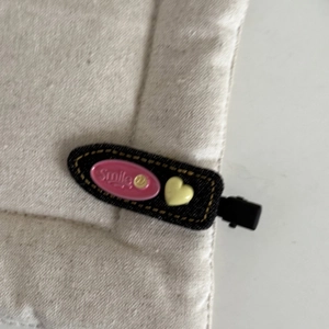 Sweet denim fabric hair clip with a pink Smile tag and yellow heart on a beige background
