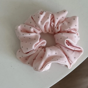 Detailed view of the soft pink lace star pattern scrunchie with delicate fabric texture