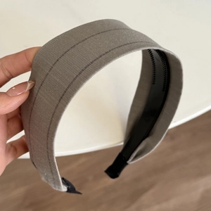 Détail du serre-tête en tissu gris avec rayures noires et dents antidérapantes