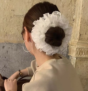 Detail view of large white organza lace hair scrunchie with layered pleats on hair