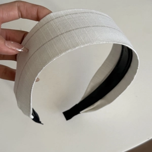 Gros plan du serre-tête large rayé beige avec dents antidérapantes noires pour maintien