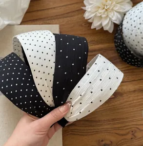 Close-up of wide polka dot and solid fabric headbands with elegant textured fabric details