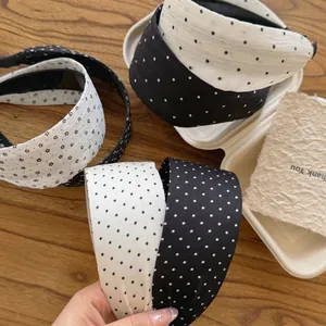 Korean style wide fabric headband with polka dot and star patterns on a wooden table