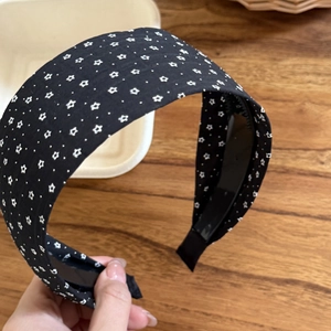 Detail of black wide headband with white star pattern and non-slip inner teeth grip