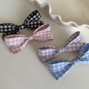 Detailansicht von vier karierten Gingham-Schleifen-Haarspangen in Pastellfarben