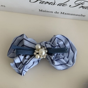 Détail d'un nœud papillon rayé pour cheveux avec perles et cristaux style nautique