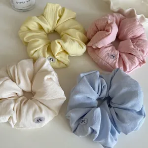 Set of 4 pastel cotton scrunchies in yellow, pink, white, blue with bow buttons