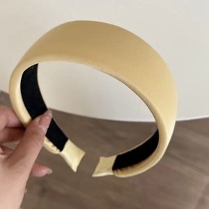 Detail of light yellow satin wide headband showing silky texture and anti-slip inner lining