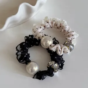 Gros plan de chouchous en dentelle à pois avec perles fantaisie et détails strass