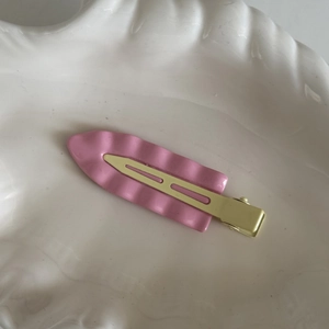 Fermaglio per capelli rosa a onde con clip dorata su vassoio bianco, stile dolce ins