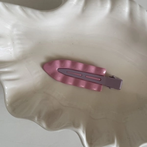 Fermaglio per capelli ondulato rosa e viola su vassoio a conchiglia per uno stile chic