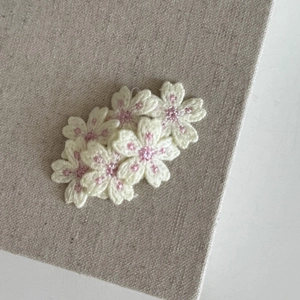 Vue macro détaillée des barrettes à fleurs de cerisier brodées avec cœurs roses