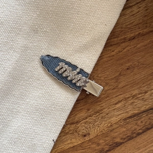 Vue détaillée de la barrette en jean avec lettrage en cristal sur base bec de canard