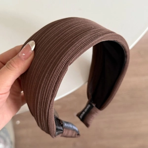 Detail eines kaffeebraunen gerippten Stirnbands mit rutschfestem Futter und Etikett