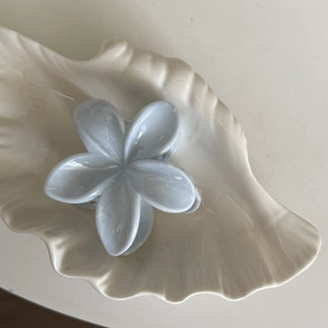 Pince à cheveux fleur bleu ciel avec texture marbrée pour cheveux épais sur plateau