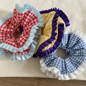 Trois chouchous à carreaux avec bordures volantées en coton rouge, jaune et bleu