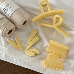 Set di mollette per capelli in resina giallo crema su pizzo e sfondo in legno scuro