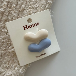 Primo piano di fermagli per capelli a forma di cuore color crema e blu grigio
