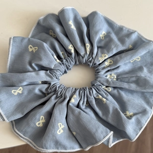 Blue oversized scrunchie with white bow patterns and elastic fabric for women