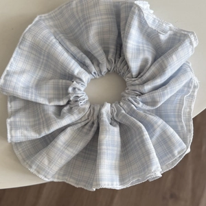 Blue and white checkered oversized scrunchie in fresh cotton-linen fabric on white table