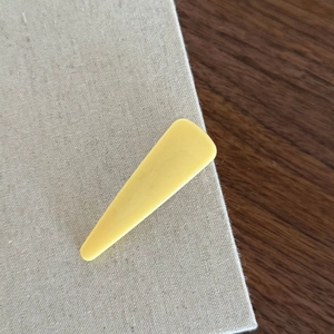 Fermaglio per capelli geometrico giallo crema minimalista con finitura opaca su fondo