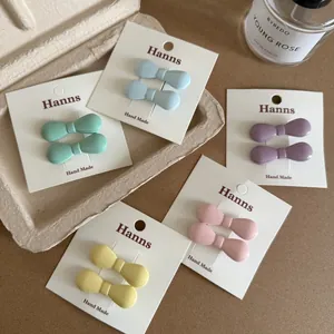 Détail de barrettes à cheveux nœuds mats colorés sur cartes d'emballage chic