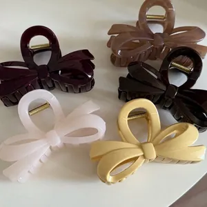 Minimalist bow hair claw clips in assorted colors like burgundy, brown, and cream