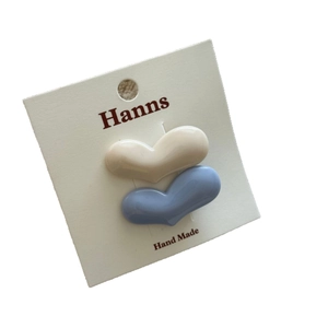 Set di due fermagli per capelli a forma di cuore in bianco crema e azzurro su carta