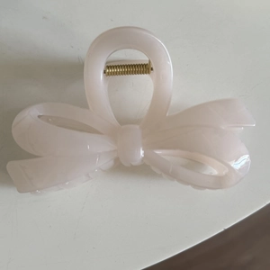 Minimalist pink bow hair claw clip made of glossy acrylic with strong gold metal spring
