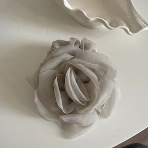 Gros plan détaillé d'un chouchou rose en maille grise sur une assiette en céramique