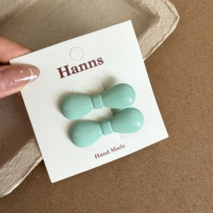 Vue détaillée de pinces à cheveux nœud vert menthe sur carte avec finition brillante