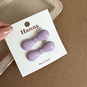 Détail de deux barrettes à cheveux violettes en forme de nœud sur une carte d'affichage