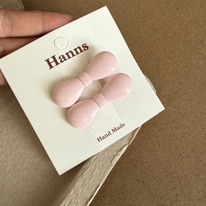 Gros plan de barrettes à cheveux nœud rose avec une finition céramique sur carte de marque