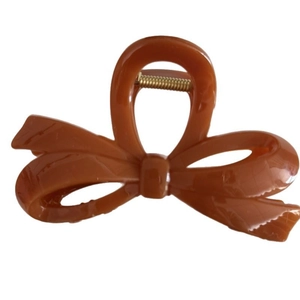 Minimalist chocolate brown bow hair claw clip with a glossy finish for women's styling
