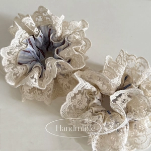 Chouchou fait main en dentelle crème avec broderie à rayures bleues et détail floral