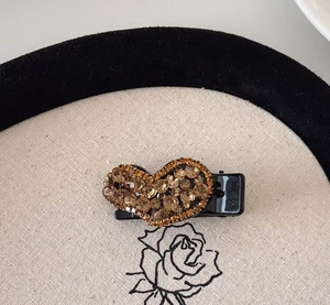 Vue détaillée de la pince à cheveux en forme de cœur avec strass couleur champagne