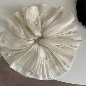 Détail du grand chouchou blanc plissé orné de perles élégantes pour cheveux