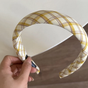 Detail shot of yellow and brown plaid padded headband showing soft cotton texture and tag