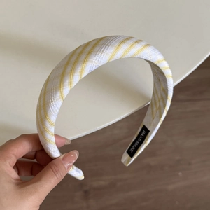 Detailed view of yellow plaid headband with a handmade label on the inner lining