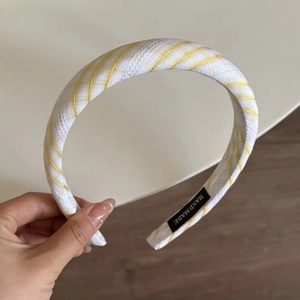 Detailed view of yellow plaid fabric headband with lace trim and handmade label