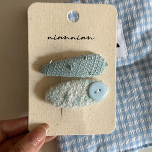 Handmade blue floral tweed hair clip set with beads and buttons on a display card