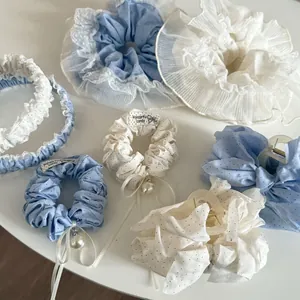 Detailed set of blue and white polka dot lace hair ties with pearls and ribbon bows