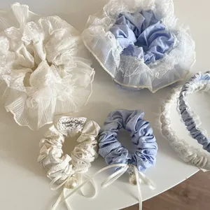 Detail view of blue polka dot lace hair scrunchies with pearls and ribbon bows set