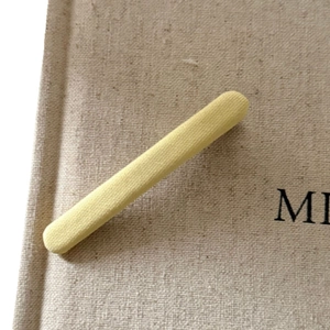 Cream yellow knitted fabric elastic hair band on beige linen background accessory for women