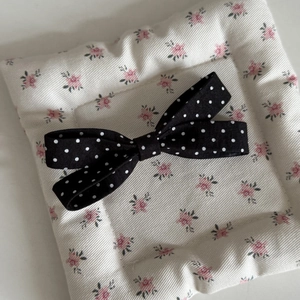 Detailed close-up of a French style black and white polka dot fabric bow hair clip