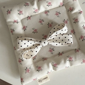 Detail of quilted floral fabric hair accessory with a black and white polka dot ribbon bow
