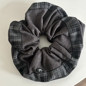 Detail of vintage grey plaid scrunchie with a bow button ornament on white background