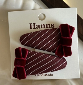 Detail of burgundy plaid hair clips with velvet bows on display card, set of two