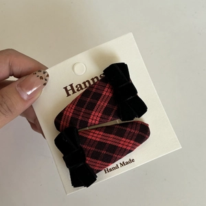 Detail view of retro red and black plaid hair clips with black velvet bow accents