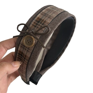 Vintage brown plaid headband with decorative button and bow for a classic retro look